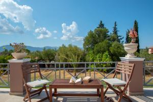 uma mesa de madeira e 2 cadeiras numa varanda em Elegant Villa Zakynthos em Kalamaki