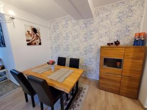 a dining room with a wooden table and chairs at Morii Lake Apartment in Bucharest