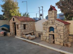 a building with a tower and a small building with a stove at Hotel Tsagarakis Beach in Amoudara Herakliou