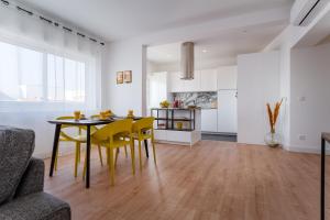 une cuisine et une salle à manger avec une table et des chaises jaunes dans l'établissement Lovely Apartment in Portimão with River view, à Portimão