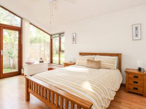 a bedroom with a large bed and a large window at 1 Aleutia Gardens in Thetford