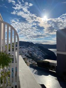 a view of a city from the balcony of a building at ArmonOia Suites in Oia