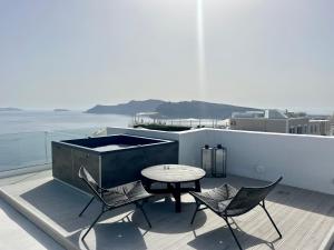 a patio with a table and chairs on a roof at ArmonOia Suites Santorini in Oia