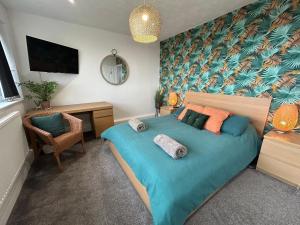 a bedroom with a bed with a blue comforter and a desk at Seaview House in Cleveleys