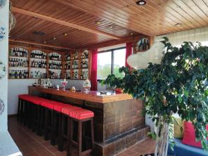 a bar with red stools in a room at Hotel Tsagarakis Beach in Amoudara Herakliou