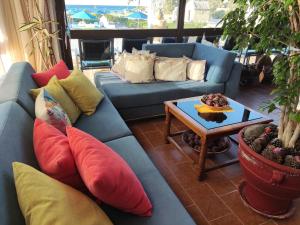 a living room with a blue couch with pillows and a table at Hotel Tsagarakis Beach in Amoudara Herakliou