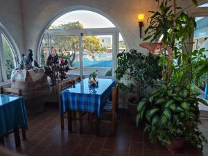 a dining room with a blue table and some plants at Hotel Tsagarakis Beach in Amoudara Herakliou