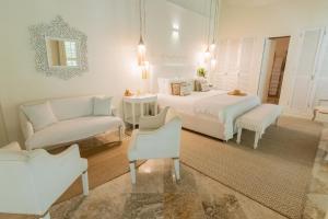 a white bedroom with two beds and a couch at Casa Diluca Cartagena Hotel Boutique in Cartagena de Indias