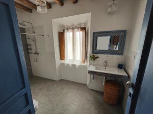 y baño con lavabo, ducha y espejo. en Vivienda rural del salado, en Jaén