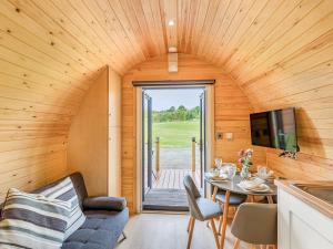 a living room with a table and a tv in a tiny house at Oak-uk36258 in Llanfair Caereinion