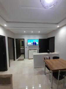 a living room with a table and a tv on a wall at Residence vip in Nador