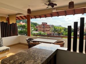 a balcony with a table and chairs and a view at Villa el Arca in Zihuatanejo
