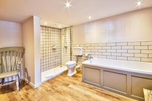 a bathroom with a bath tub and a toilet at The Woolpack Inn in Coggeshall