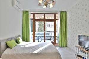 a bedroom with a bed with green curtains and a television at Křižíkova 4 in Karlovy Vary