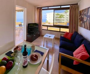 una sala de estar con una mesa y un sofá en Vista La Gomera - 2 minutes walk from the beach!, en Puerto de Santiago