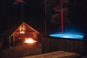 a igloo and a hot tub in the woods at night at Raanakka House - Premium Villa at Levi in Levi