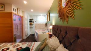 a living room with a couch and a green wall at Votre Escale Jungle Sauna & Spa in Niort