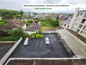 een parkeerplaats met twee auto's erin geparkeerd bij DL LES 4 SAISONS - Meublé Tourisme 3 Etoiles in Brive-la-Gaillarde