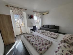 um quarto de hotel com duas camas e um sofá em Apartment Evie - Central Historical Quarter em Rijeka