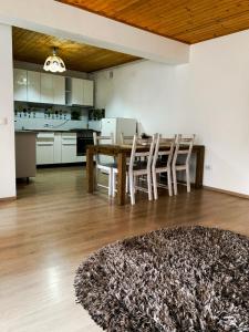 een woonkamer met een tafel en stoelen en een keuken bij LONDOF Housing City Center Brasov in Braşov