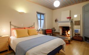 1 dormitorio con 1 cama y chimenea en Kyriaki Guesthouse & Suites en Amfiklia