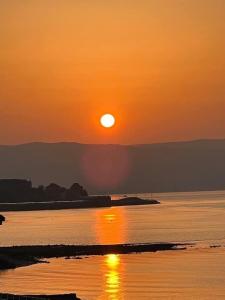 a sunset over a body of water with the sun setting at clyde hub in Gourock
