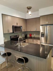 a kitchen with a counter with a sink and a refrigerator at Midtown 4 bedroom home Free Wi-Fi and parking in Toronto