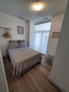 a bedroom with a bed and a large window at Midtown 4 bedroom home Free Wi-Fi and parking in Toronto