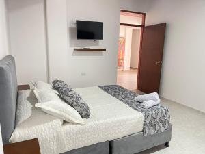 1 dormitorio con 1 cama y TV de pantalla plana en Casa Hotel Estelar, en Villavieja