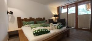 a bedroom with a bed with green and white pillows at Zugspitzchalets in Biberwier