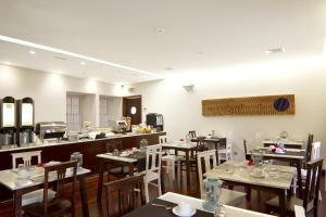 a restaurant with tables and chairs and a counter at Oca Ribeira do Porto Hotel in Porto