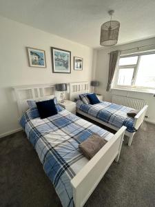 a bedroom with two beds and two windows at Seapoint House in Cleveleys