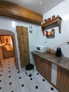 a kitchen with a sink and a counter with a microwave at Casa Rincón in Iznatoraf
