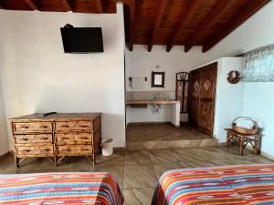 a bedroom with a dresser and a tv on the wall at Villa el Arca in Zihuatanejo