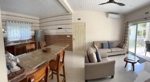 a kitchen and living room with a table and a couch at Coco De Mer Villa in Mahe