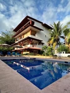 a resort with a swimming pool in front of a building at Villa el Arca in Zihuatanejo