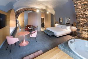 pokój hotelowy z łóżkiem i wanną w obiekcie BASTIÒ PRIVATE SUITES w Katanii