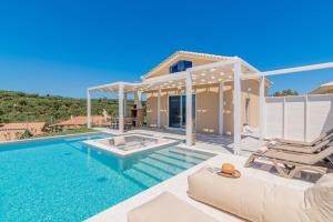 a villa with a swimming pool and a house at Spartakos Luxury Villa 1 in Plános