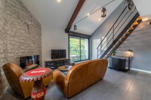 sala de estar con sofá y chimenea en La Fabrique, Loft 100 m2, en Rives