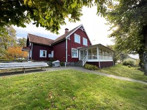 una casa roja con un banco en el patio en Unique house in Kopmannebro with fantastic lake plot, en Köpmannebro