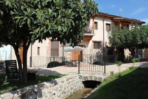 Molino de La Médica Casa Rural de Lujo en Gredos في كانديليدا: منزل به شجرة وجدار حجري