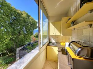 a kitchen with a large window and a sink at Apartment Kantrida-Near the Beach in Rijeka