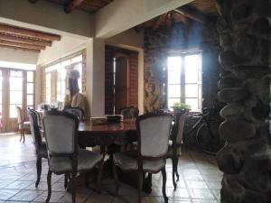 Hermoso lugar familiar cerca a Villa de Leyva في Sutamarchán: غرفة طعام مع طاولة وكراسي خشبية