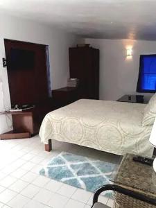 a bedroom with a bed and a flat screen tv at Villa Kaiae in Sandy Ground Village