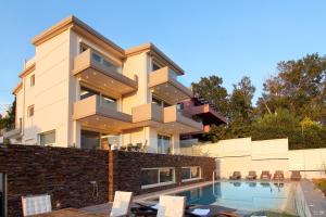 a building with a swimming pool in front of it at Villa Nelmar in Anavyssos