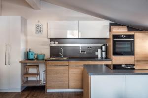 eine Küche mit Küchengeräten aus Edelstahl und Holzschränken in der Unterkunft Penthouse „Das Besenhaus“ in Altenmarkt im Pongau
