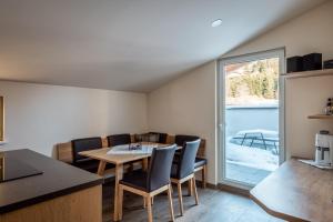 kuchnia i jadalnia ze stołem i krzesłami w obiekcie Penthouse „Das Besenhaus“ w mieście Altenmarkt im Pongau