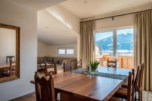 jadalnia ze stołem i dużym oknem w obiekcie Penthouse „Das Besenhaus“ w mieście Altenmarkt im Pongau