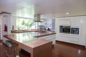 a large kitchen with white cabinets and a large island at Pug Seal Coyoacan in Mexico City