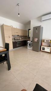 a large kitchen with a washer and dryer in it at Cristina Home in St. Paul's Bay